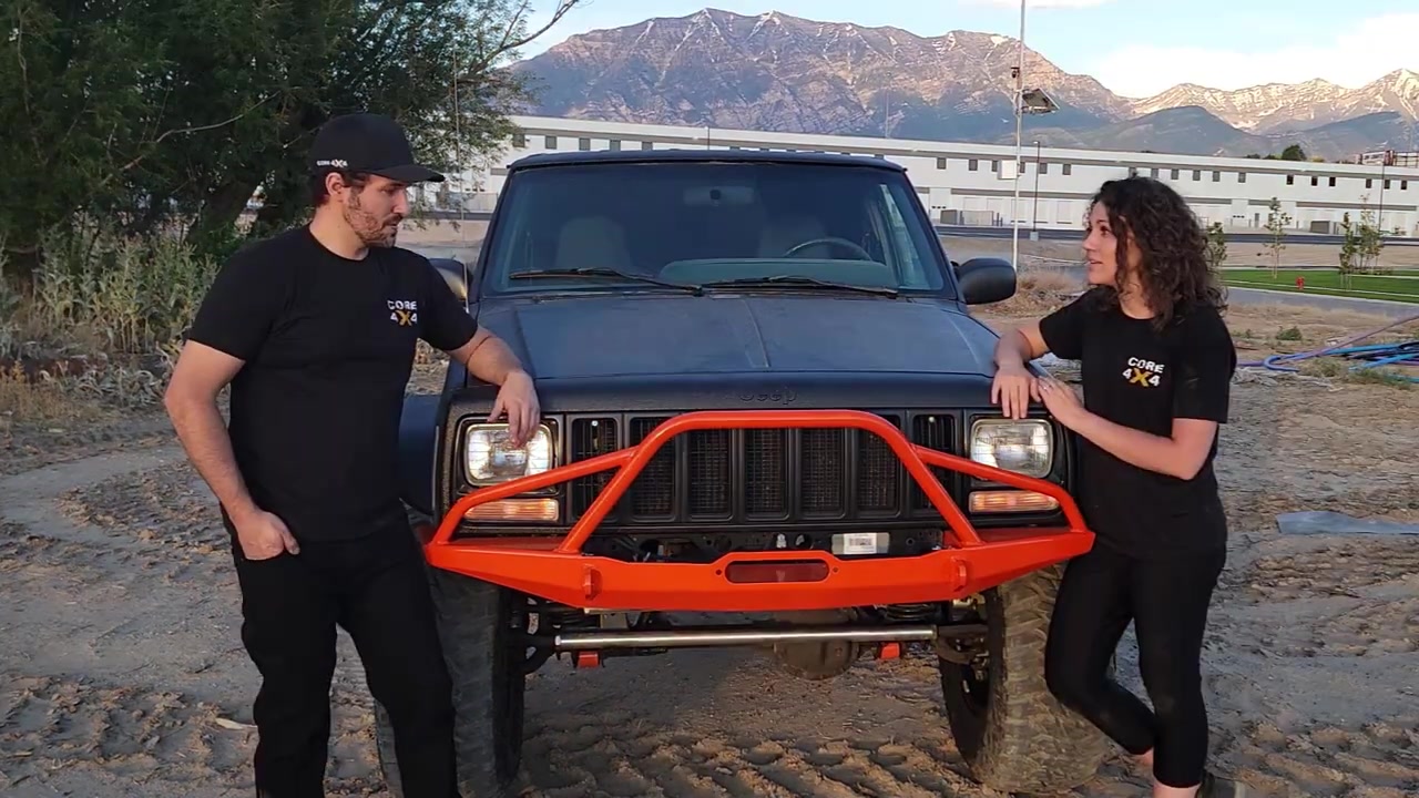 Spence and Marissa with the completed XJ Cherokee at a dirt lot with Utah mountains in the background