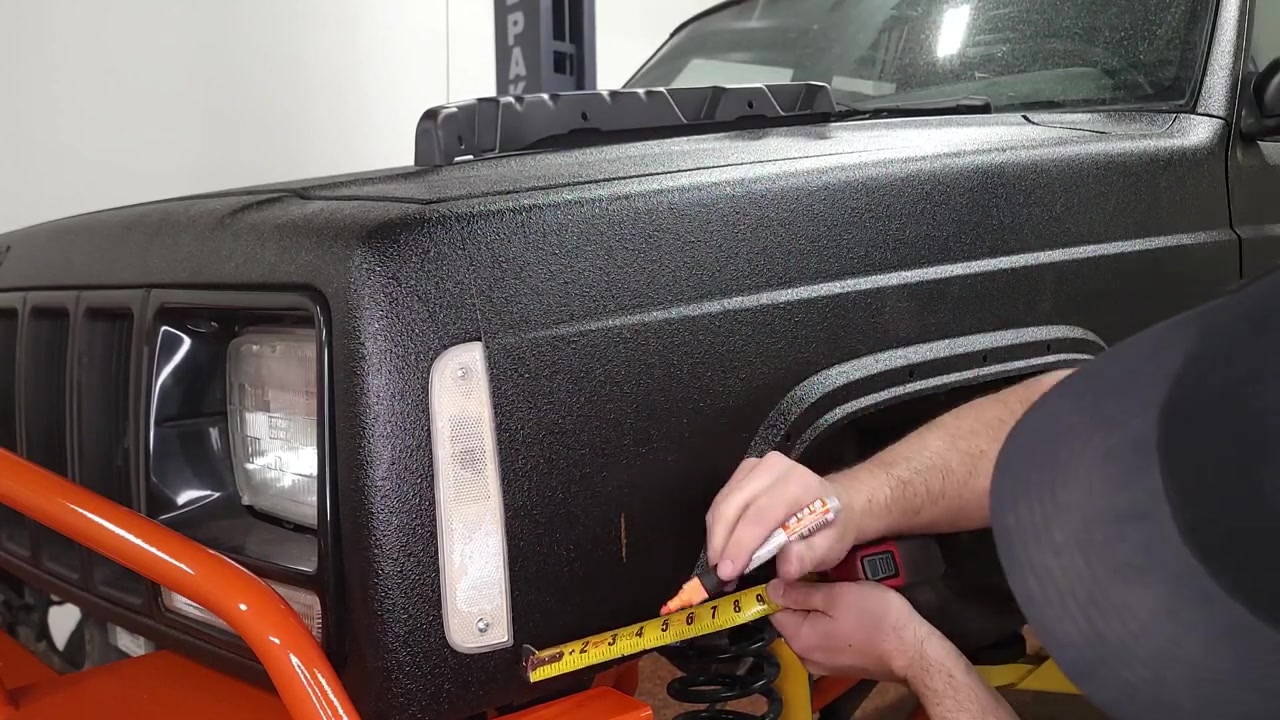 Measuring 3-3/4 inches from the front edge of the XJ fender with a tape measure and marking the drill point for the inner fender support