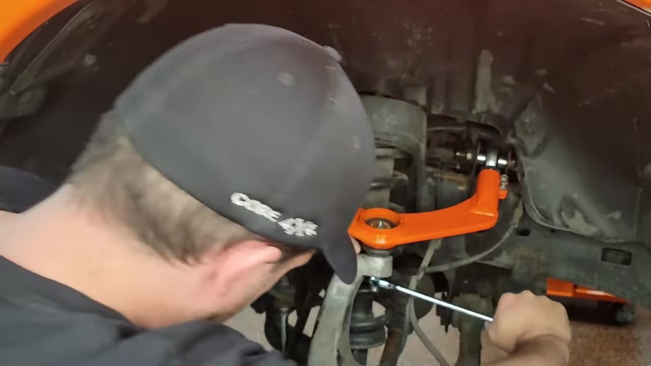 Spence torquing the castle nut on the upper ball joint with a torque wrench while the new Core 4x4 control arm is installed on the Ram 1500