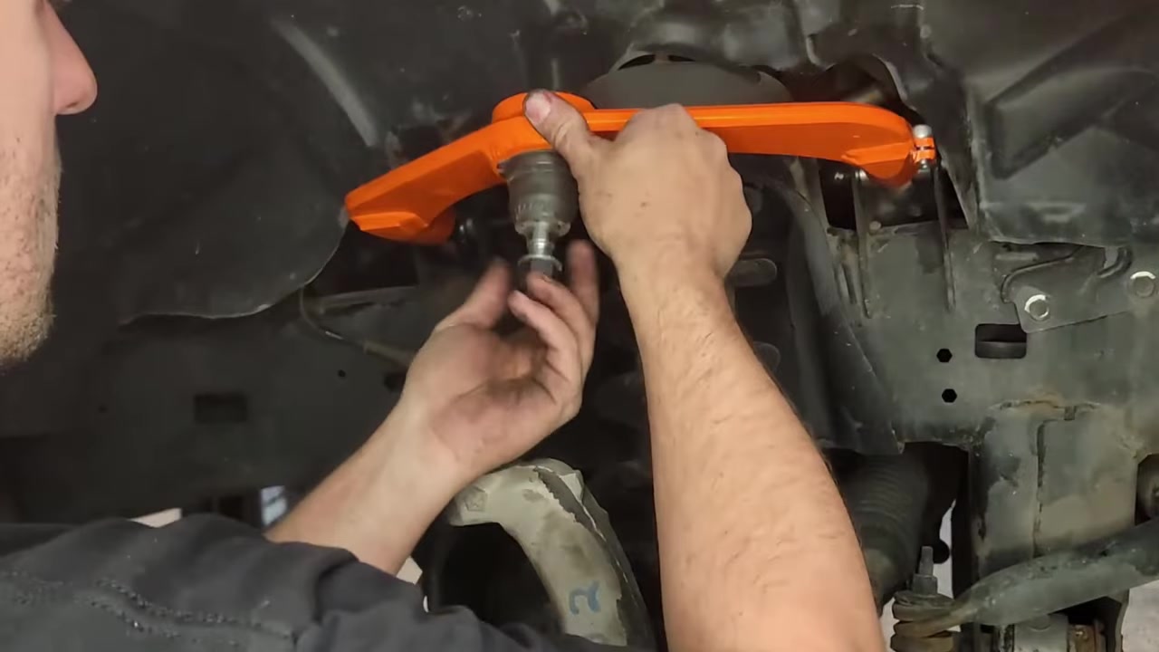 Spence adjusting the sleeve on the Core 4x4 upper control arm using the included wrench underneath the Ram 1500