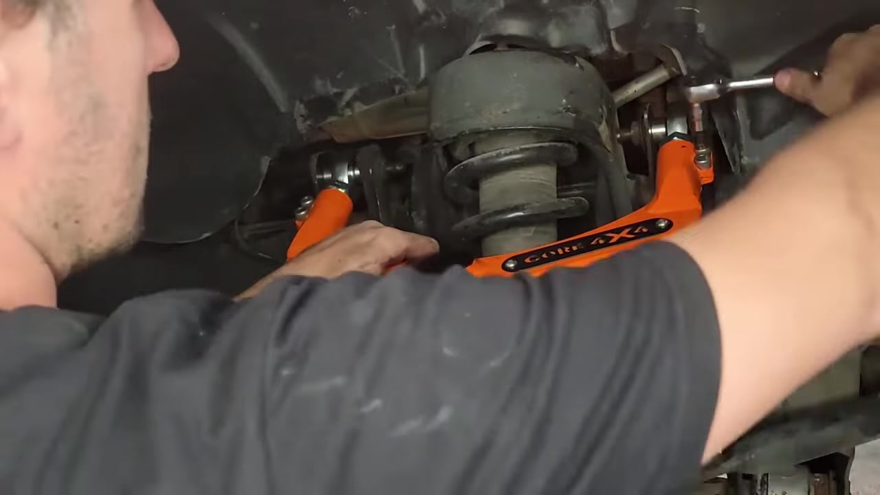 Spence showing the installed Core 4x4 upper control arm on the Ram 1500, demonstrating the corrected ball joint angle compared to the steeper factory geometry on a lifted truck