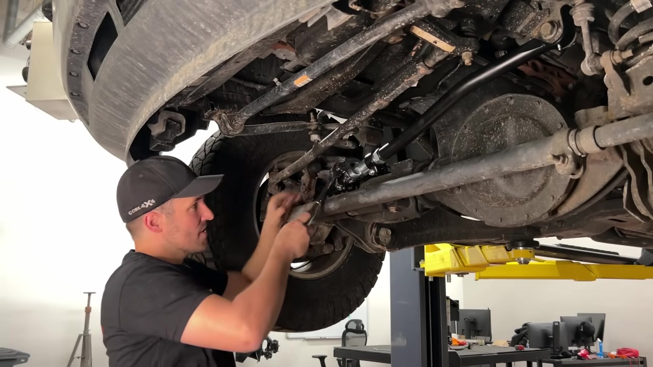 Spence adjusting the turnbuckle on the Core 4x4 track bar under the Ram 2500 to set the correct length