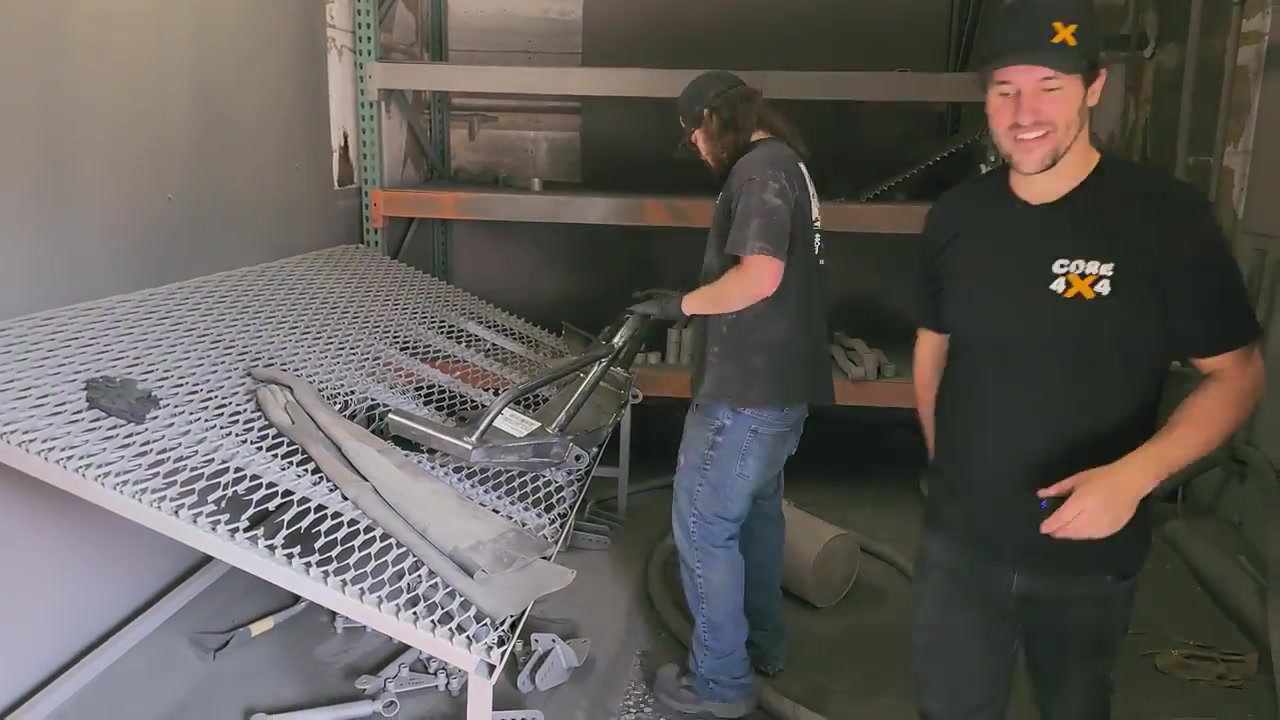 Spence loading the raw steel Dirtbound bumper and frame braces into the Core 4x4 blast room for sandblasting