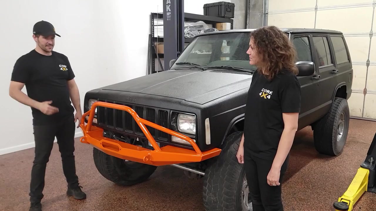 Spence and Marissa standing beside the finished XJ Cherokee with the orange powder-coated Dirtbound front bumper installed