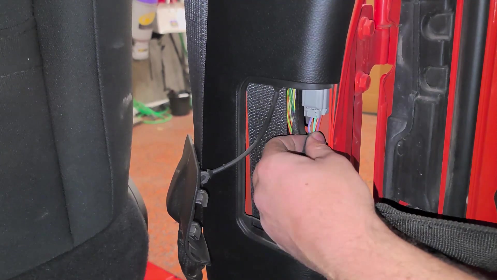 Close-up of the JL Wrangler door wiring harness connector being disconnected