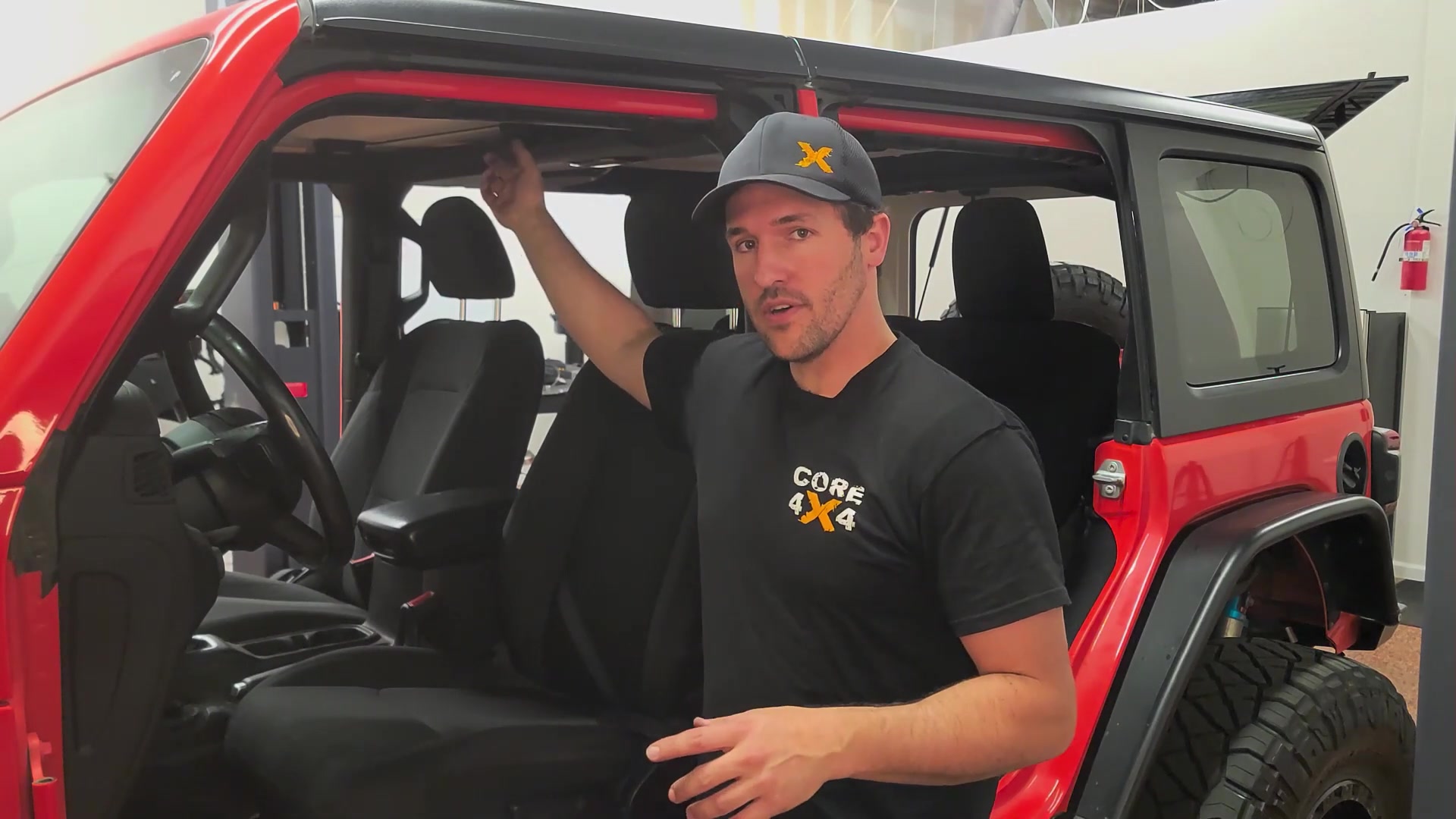 Spence standing next to the red Jeep JL with all four doors removed, freedom panels still on