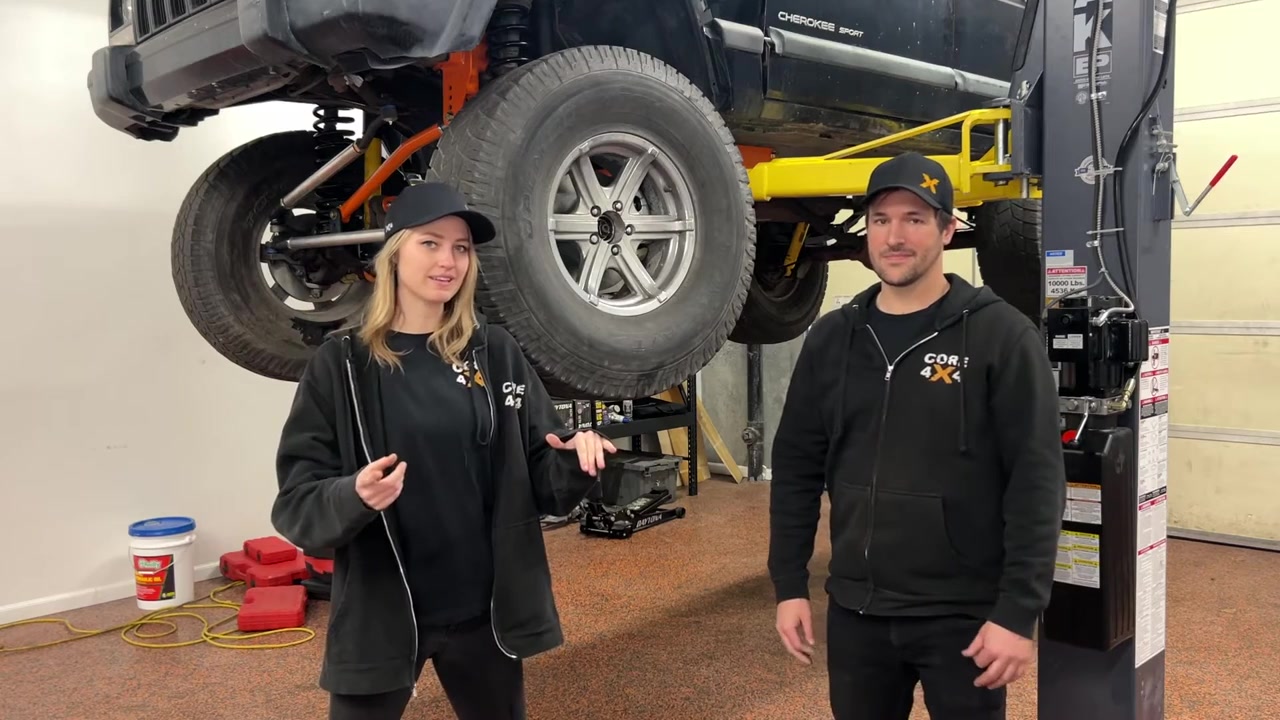 XJ Cherokee on the lift at Core 4x4 shop with brakes being prepped for bleeding and new brake lines visible