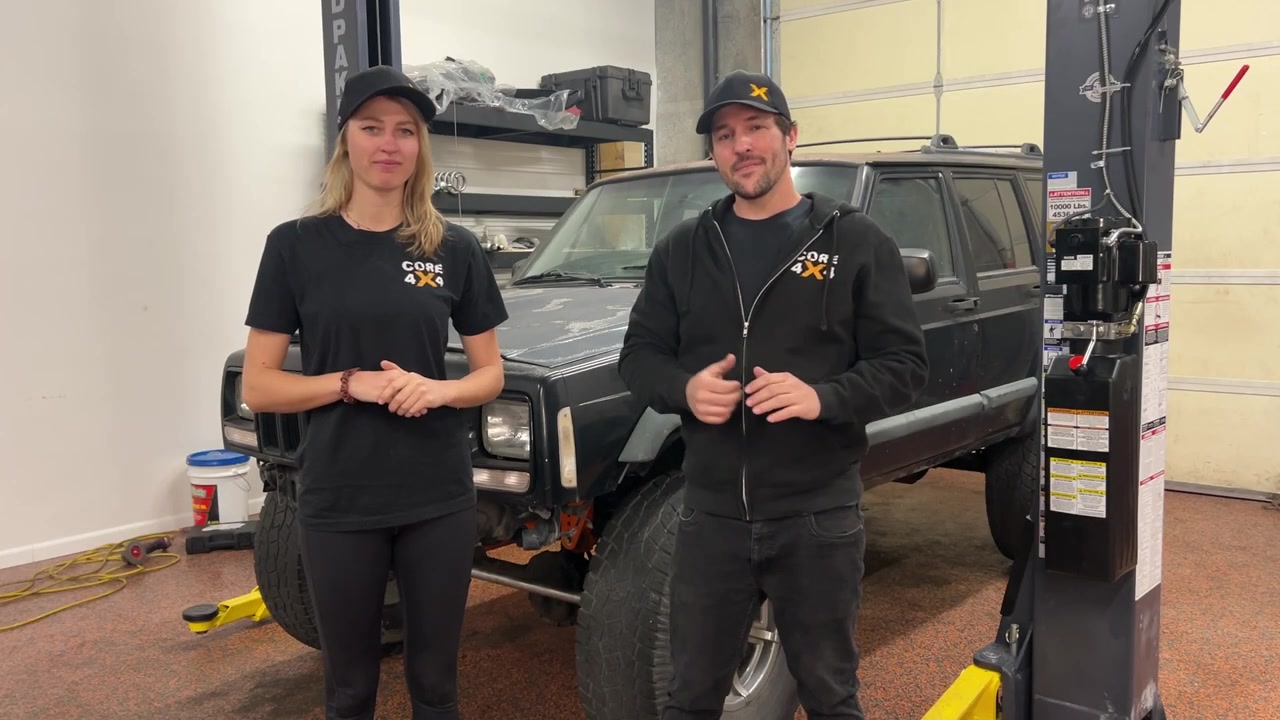 Spence and Gabby from Core 4x4 standing in front of the XJ Cherokee before the Rhino line job