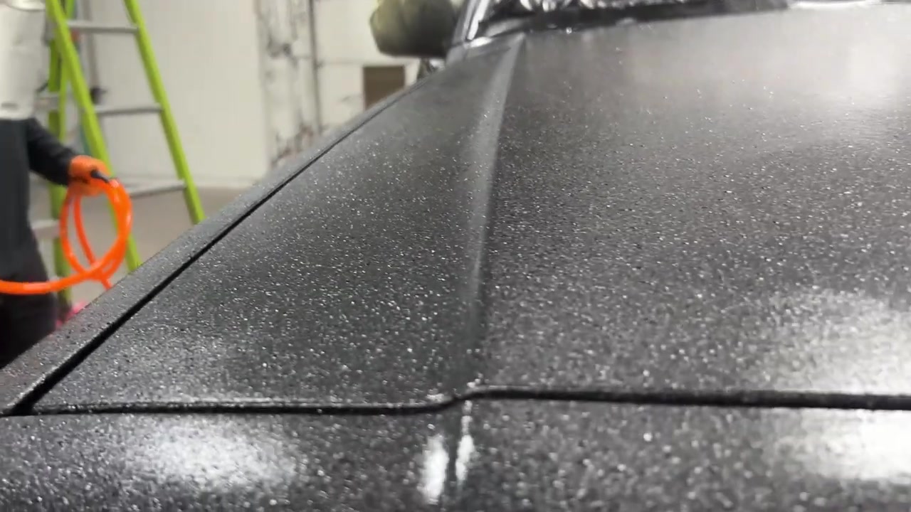 Close-up of the XJ Cherokee roof after Rhino line application showing the textured bed liner finish