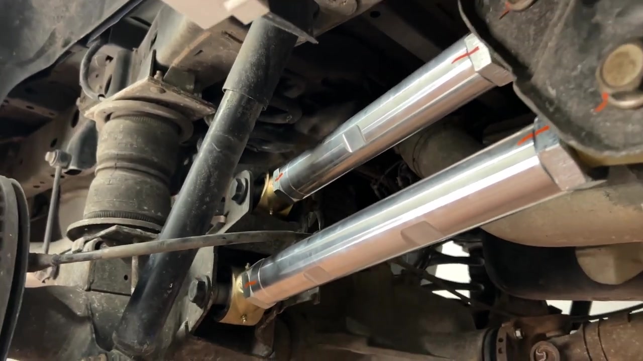 Close-up of installed Core 4x4 Aluminum Series rear control arms on the Ram 2500 axle showing the 3-inch Johnny Joints, paint marks on jam nuts, and the finished install