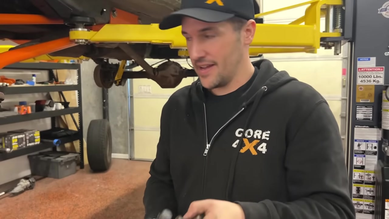 Spence in the Core 4x4 shop with the XJ Cherokee on the lift after removing the knuckles