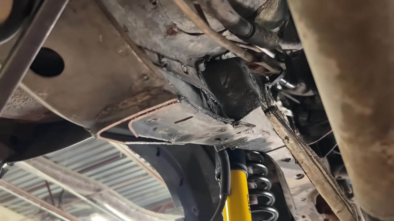 Underside of XJ Cherokee frame showing factory bracket area cut and cleared for long arm crossmember