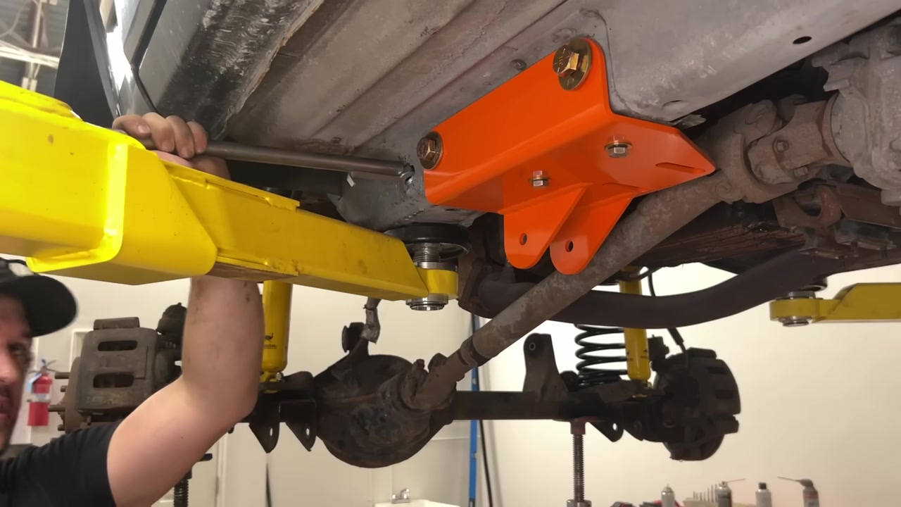 Orange Core 4x4 frame bracket and crossmember installed on XJ Cherokee with long arm being fitted