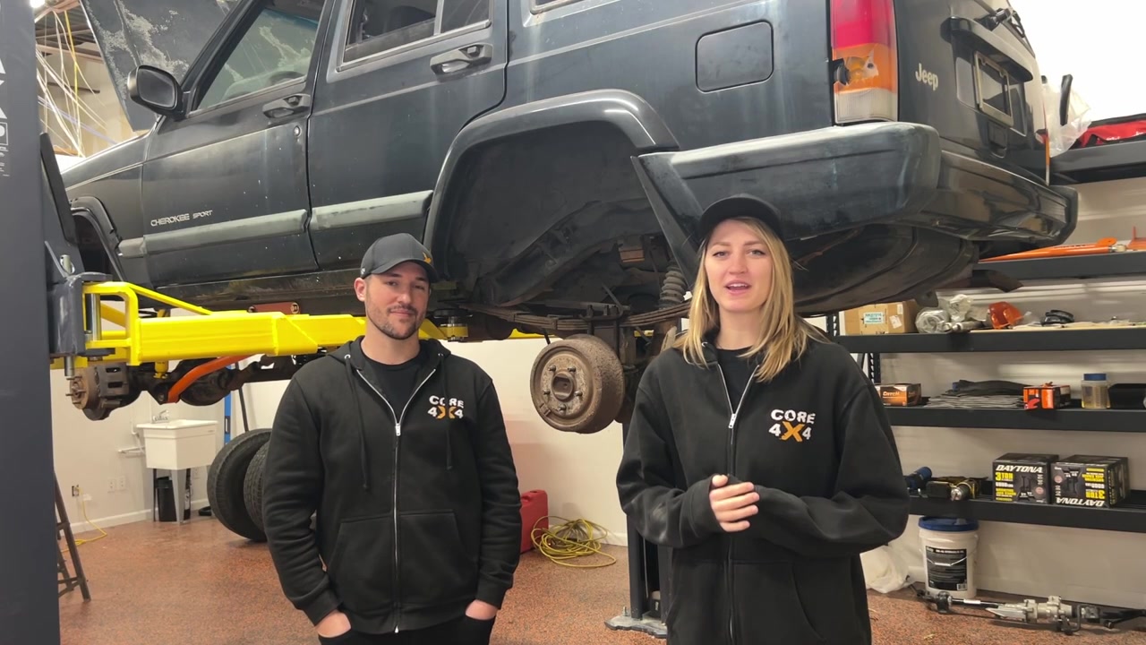 XJ Cherokee on lift ready for rear suspension teardown with Gabby and Spence from Core 4x4