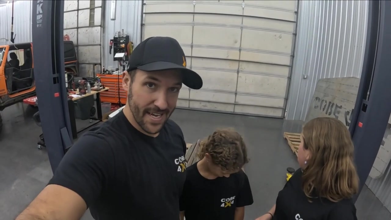 Spence with his two daughters wearing Core 4x4 shirts in the shop after getting the sandblasted and powder coated parts back