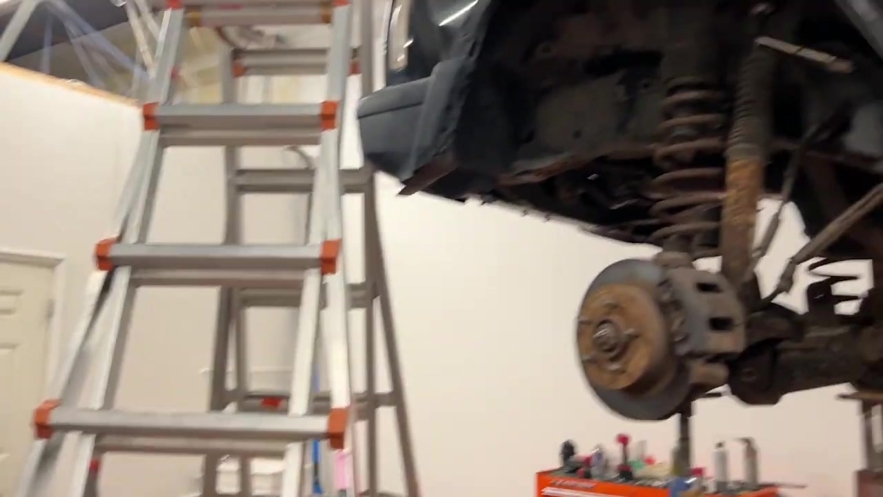 XJ Cherokee front axle stripped bare with brake rotor visible and springs removed