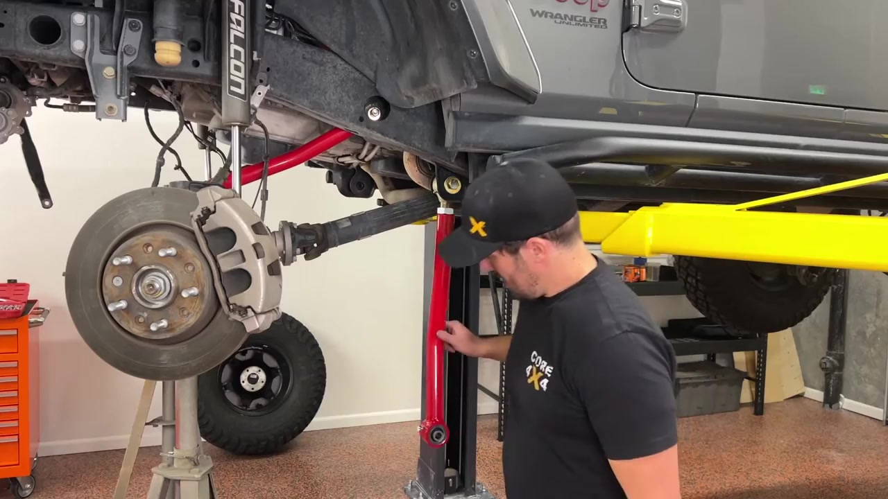 Core 4x4 red Crawl Series upper control arm installed on the JL Wrangler front axle