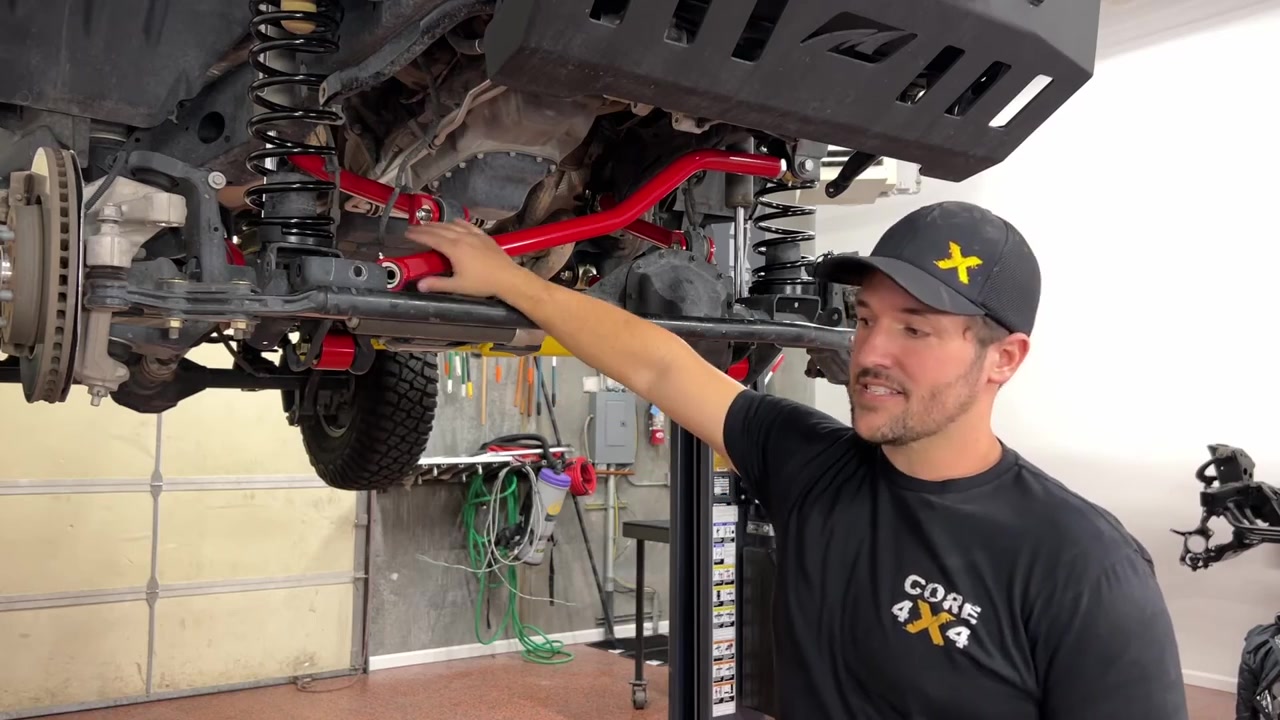 Spence showing the completed front control arm install with red Crawl Series arms visible under the JL Wrangler