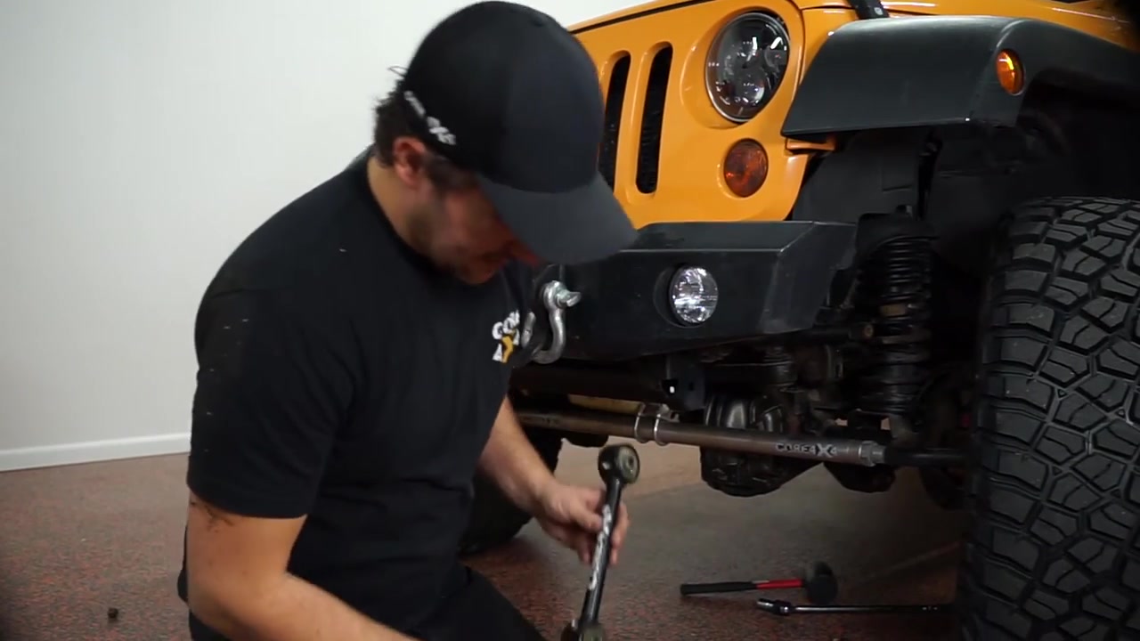 Spence installing the new Core 4x4 crawler series sway bar end link on the JK Wrangler front axle with the spacer positioned on top
