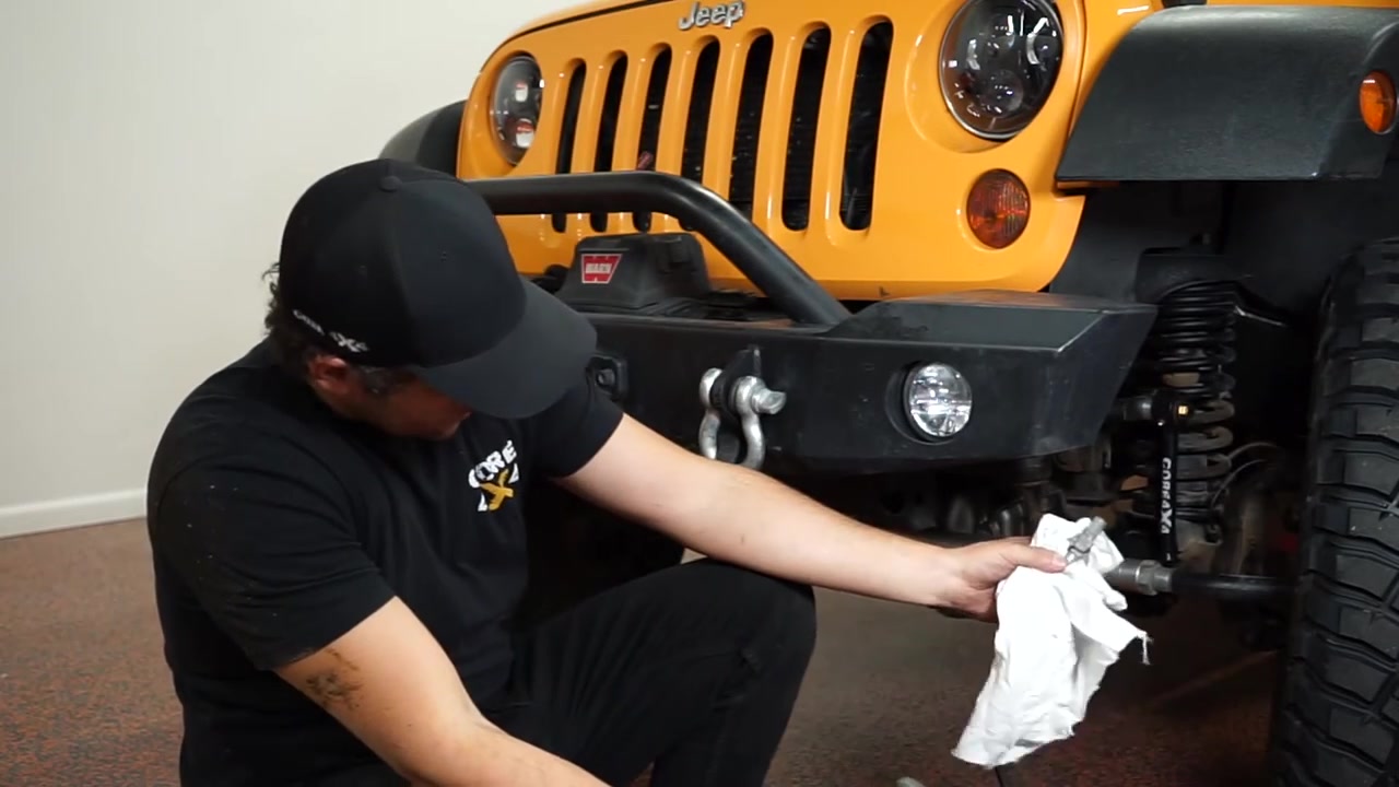 Spence wiping excess grease from the newly installed sway bar end link Johnny Joints on the JK Wrangler front end
