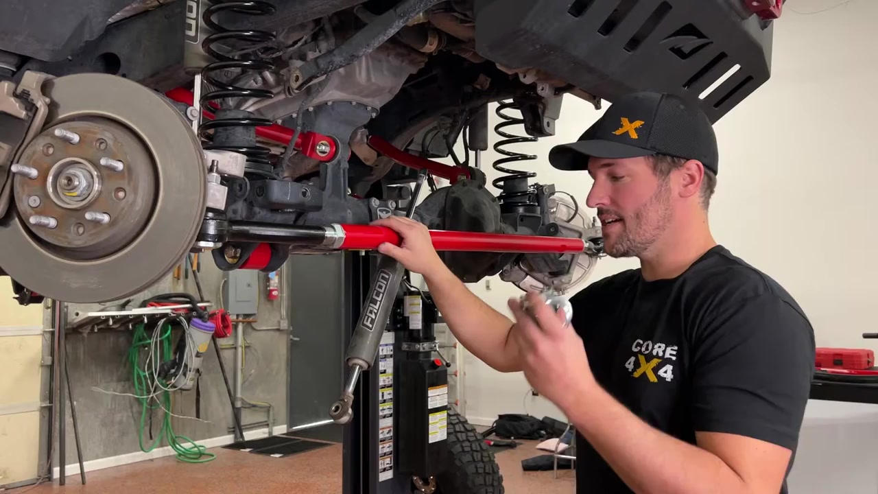 Spence installing steering stabilizer on JL Wrangler tie rod showing positioning technique