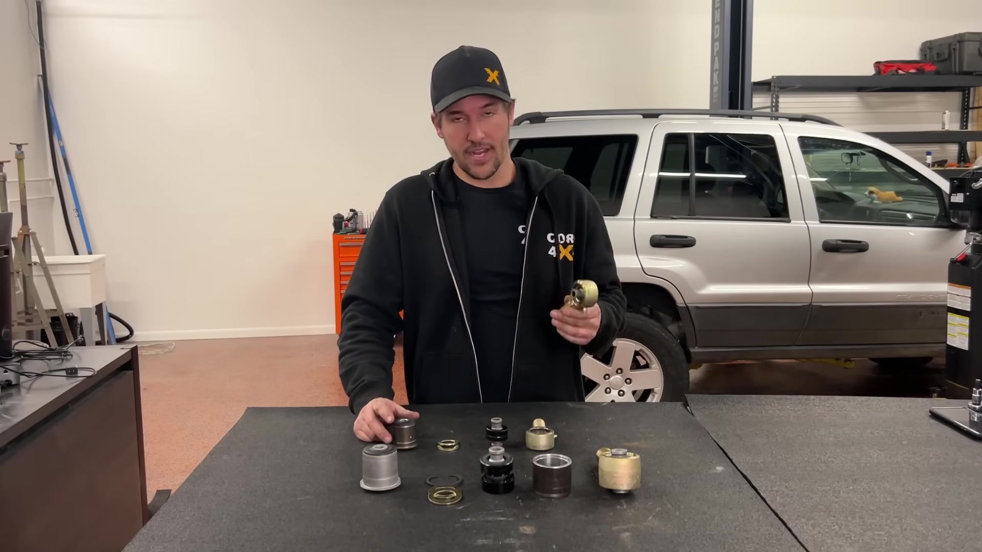 Spence holding a control arm rod end with Johnny Joint installed showing the ball center articulation