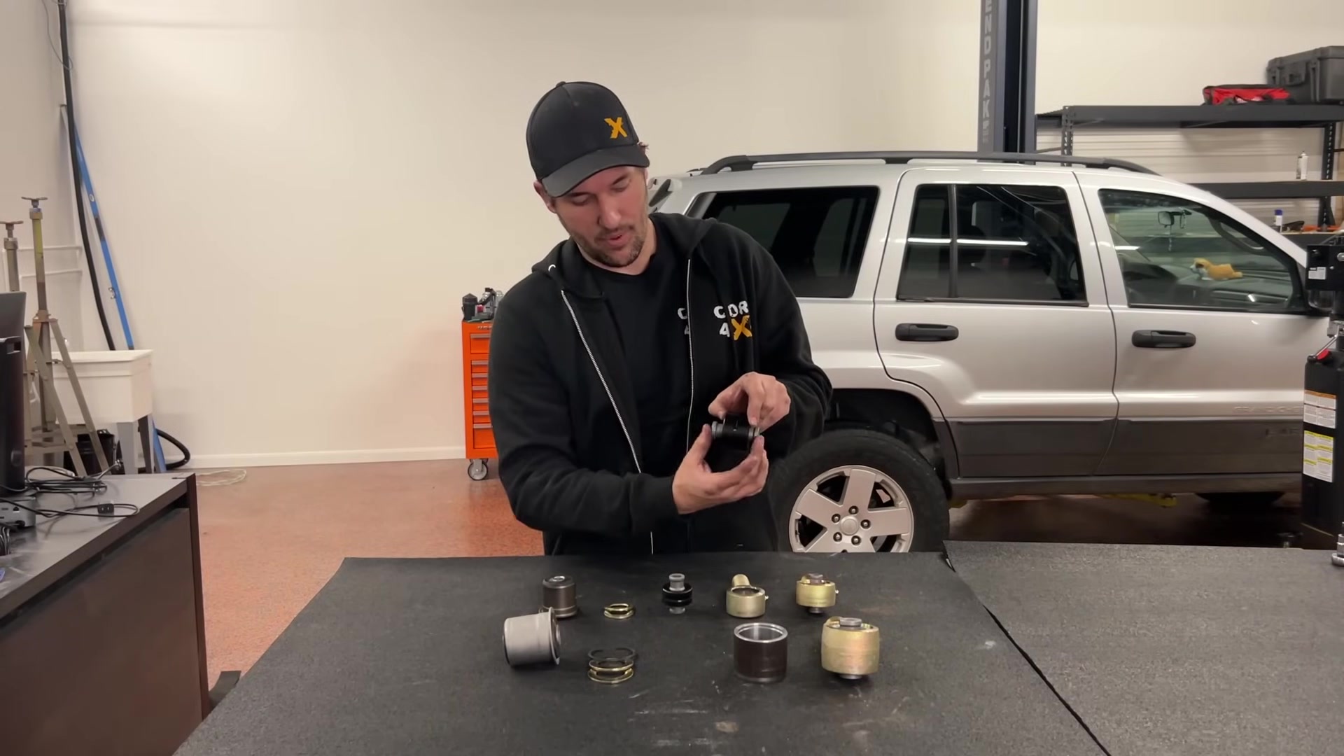 Spence comparing Johnny Joint to a spherical rod end at Core 4x4 shop workbench