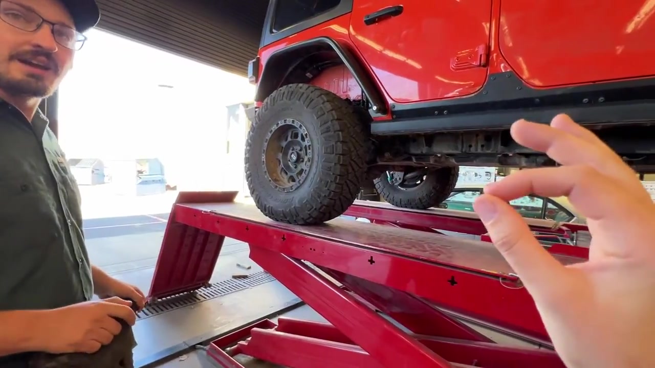 Trevor explaining the alignment process with the red JL Wrangler on the alignment rack turntables