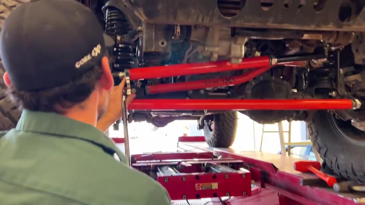 View from underneath the JL Wrangler showing the Core 4x4 red adjustable control arms and steering components on the front axle