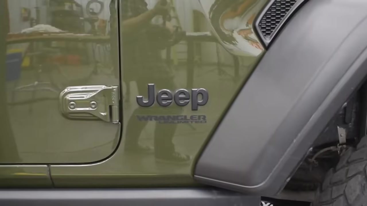 Jeep Wrangler Unlimited badge on a green JL in the Core 4x4 shop ready for a lift kit installation