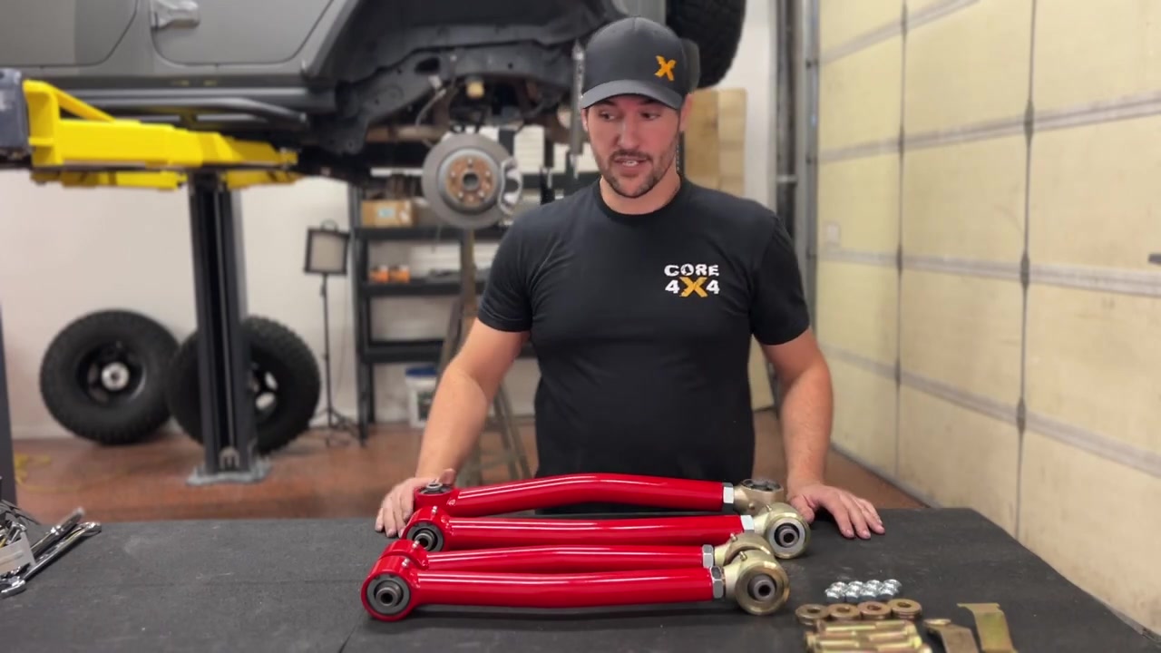 Spence at the workbench with the Crawl Series control arms, explaining how to align the Johnny Joints parallel before measuring eye-to-eye length
