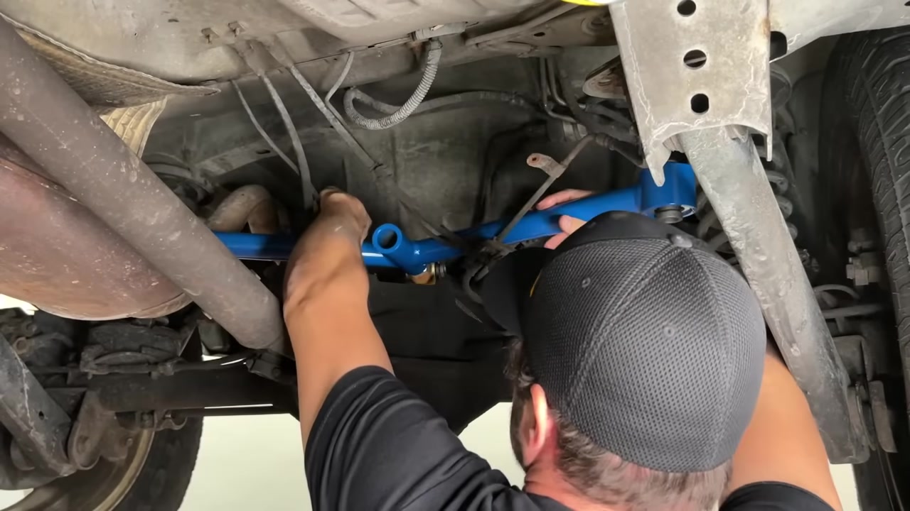 Spence bolting the new Core 4x4 Crawler Series blue rear upper A arm into the WJ with the new bracket and Johnny Joints visible