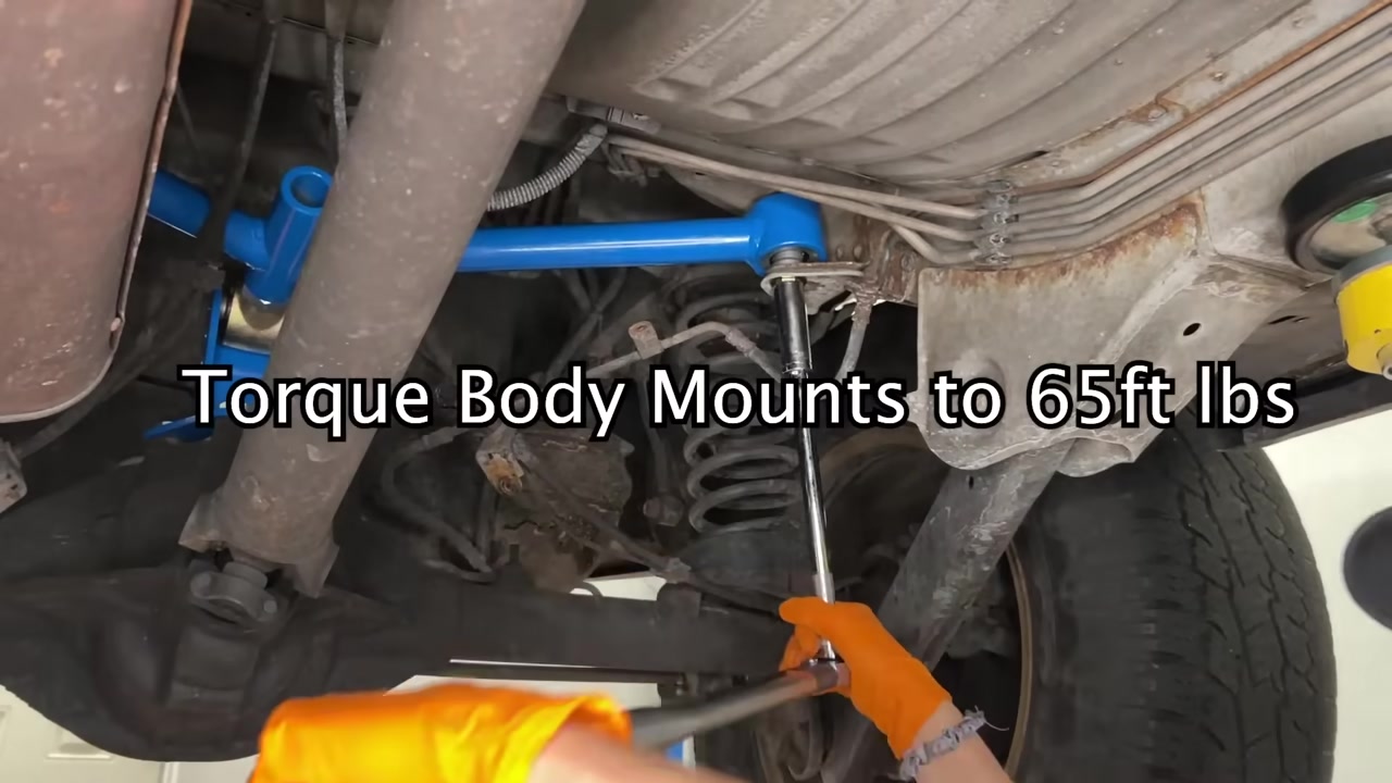 Under the WJ on the ground showing the new Core 4x4 blue A arm installed with the torque body mount spec of 65 ft-lbs displayed
