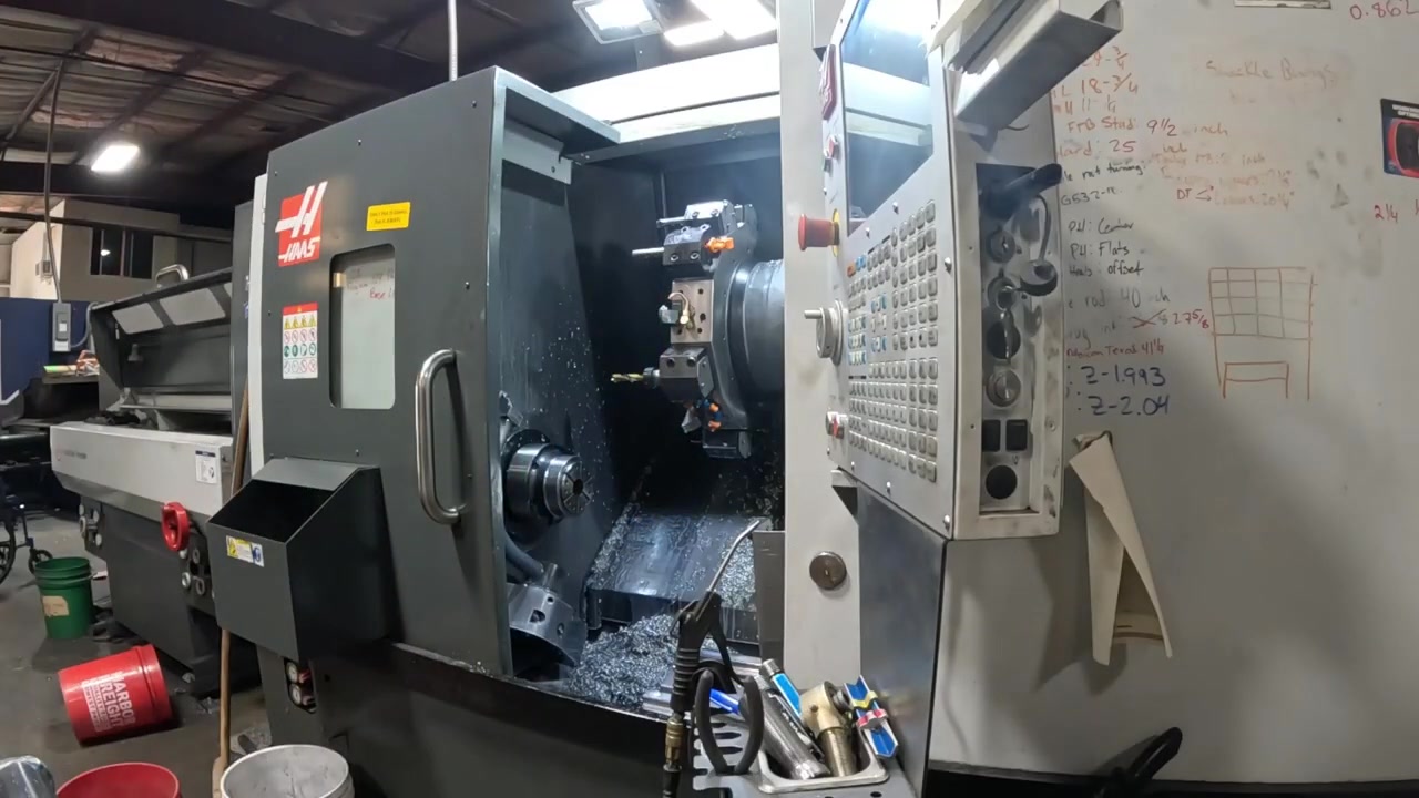 Haas CNC lathe in the Core 4x4 machine shop being used to face adjustable foot bolts for the conference table