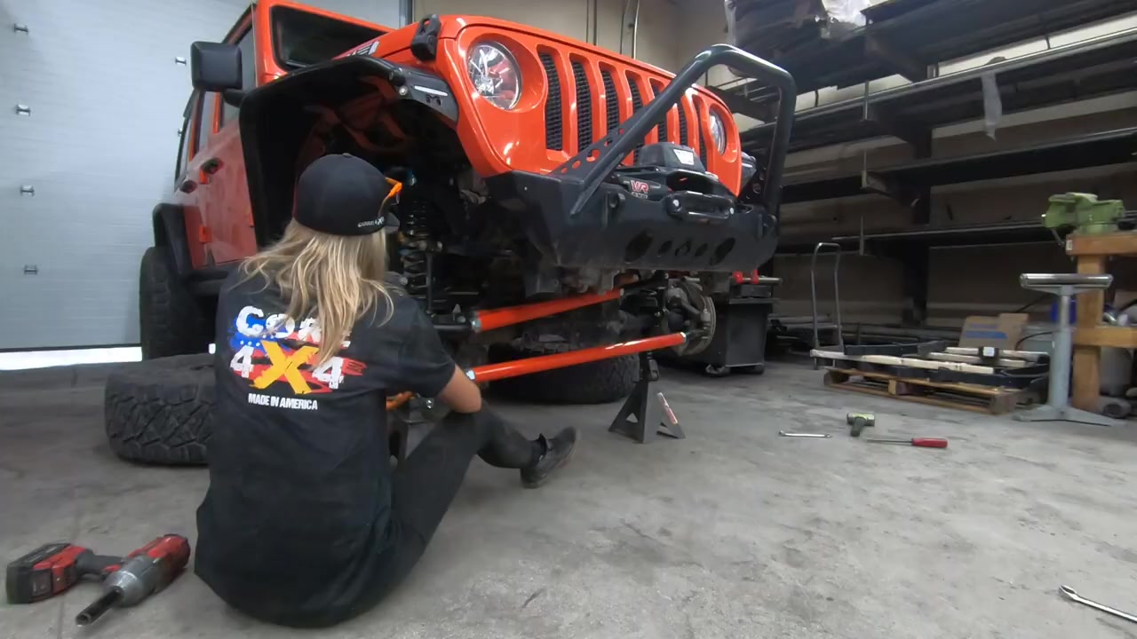 Gabby installing the Core 4x4 orange tie rod and drag link on the JL Wrangler front axle