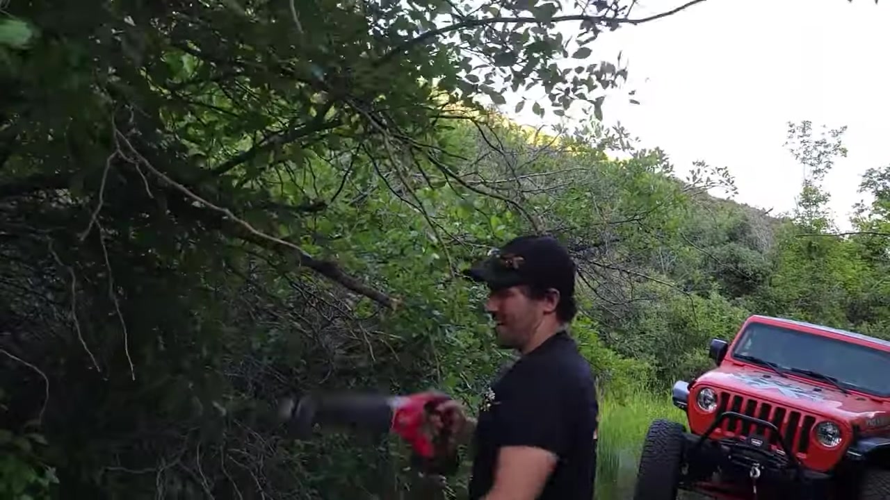Core 4x4 XJ Cherokee pushing through narrow trail with tree branches scraping the sides